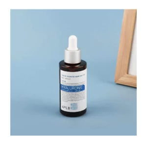 APLB Hyaluronic Acid Ampoule Serum bottle with filler with blue background showing a partial view of a photo frame