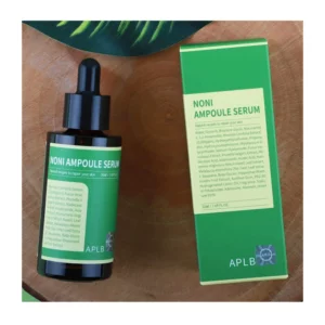 Noni Ampoule Serum Box and bottle lying on wooden base